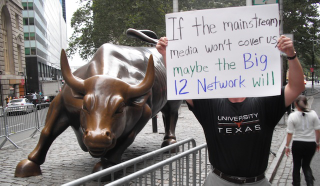 Illustration for article titled "Radiohead Wouldn't Play In The Big East Either": Occupy Wall Street Has An "Occupy Herbstreit" Photobomber
